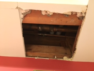 Hole in soffit left by plumbing repair.