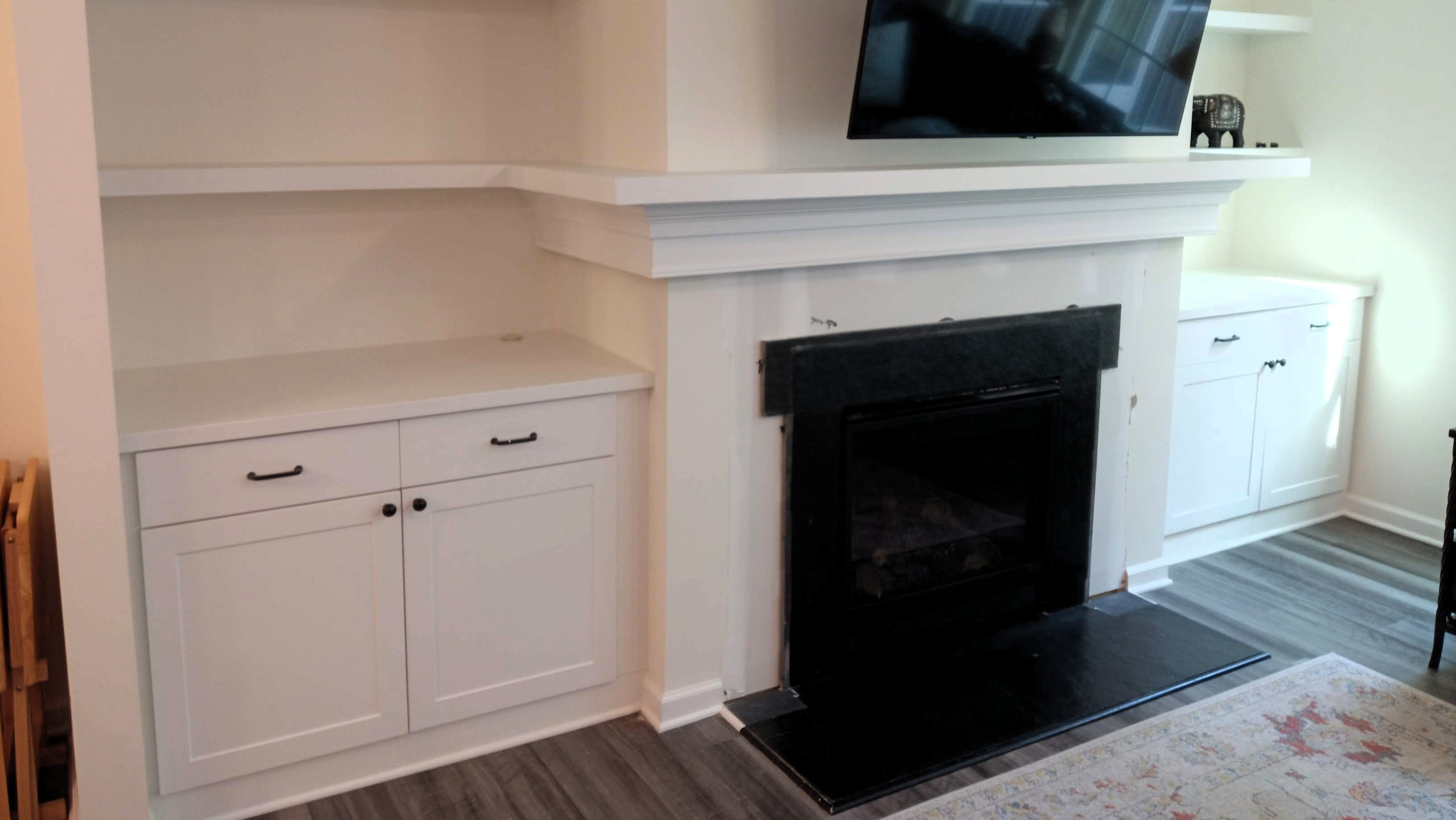 Fireplace with cabinets and floating shelves on either side