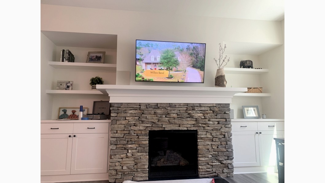 Stone fireplace with cabinets and shelves on either side